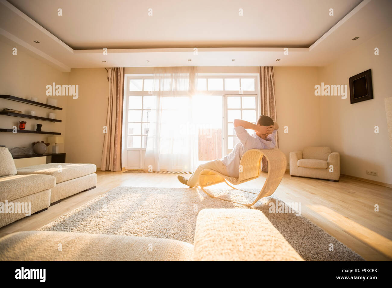 Rückansicht des Menschen entspannend auf moderner Stuhl zu Hause Stockfoto