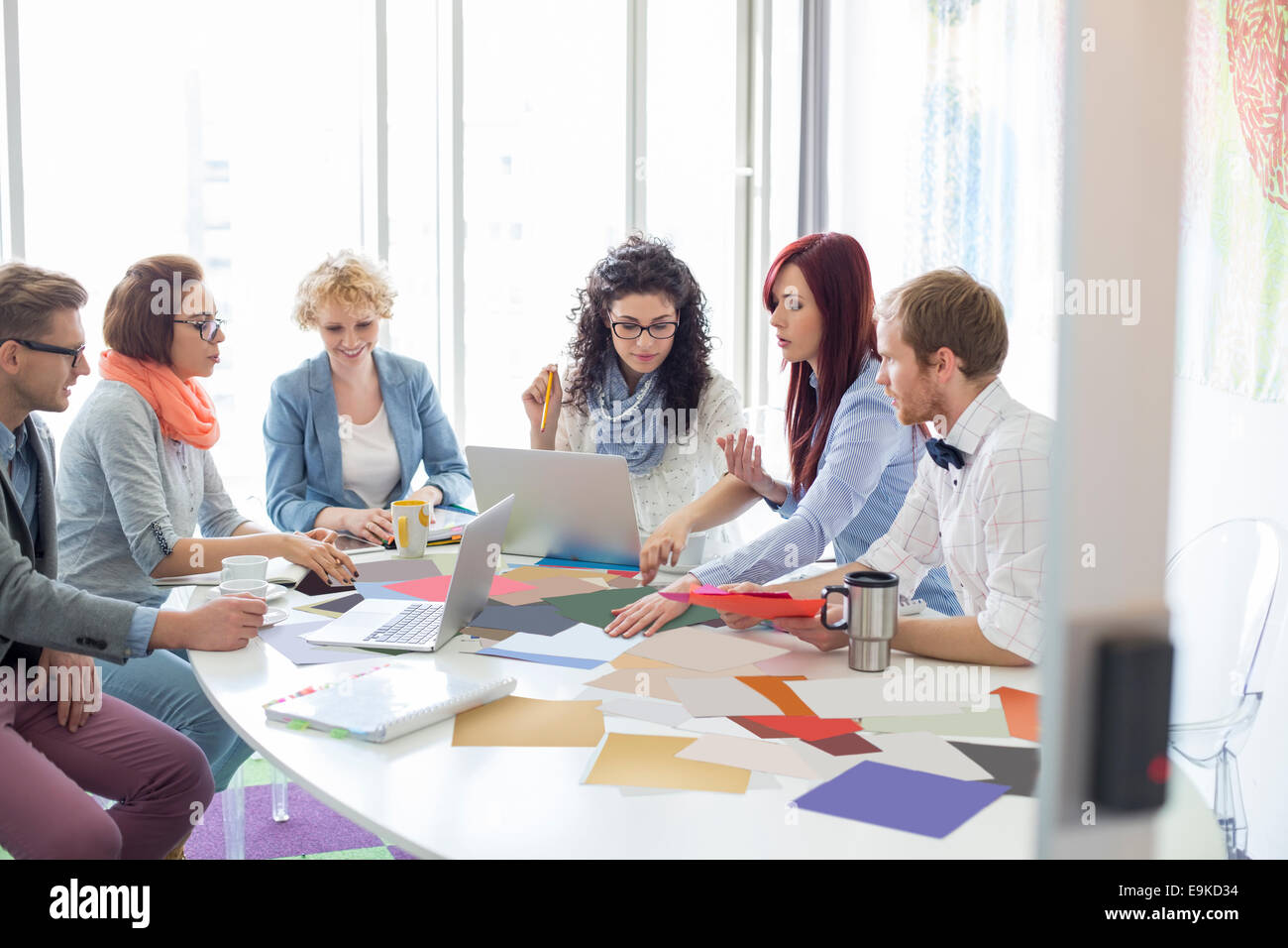 Kreative Geschäftsleute, die Analyse von Fotografien am Konferenztisch im Büro Stockfoto