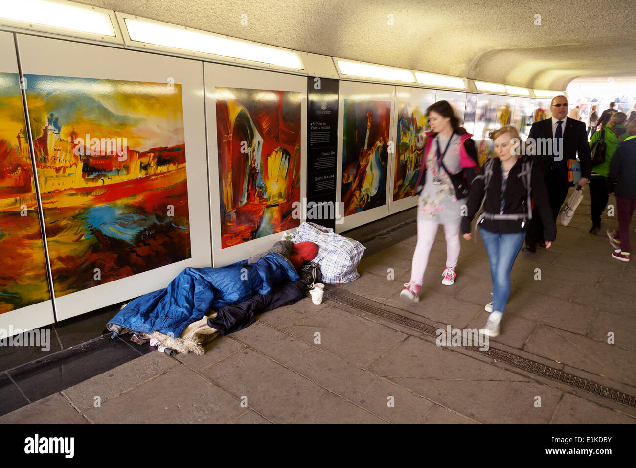 Armut Großbritannien; Obdachlosigkeit Großbritannien; Menschen, die an einer Obdachlosen vorbeigehen und in einem Schlafsack auf der Straße rauh schlafen, Tower Hill, London, Großbritannien Stockfoto