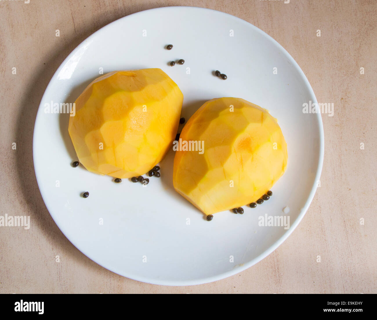 Carica Pappaya Früchte in zwei Stücke schneiden auf eine weiße Platte Oberflächenansicht gelb farbigen reich an Flavonoiden Antioxidanst platziert Stockfoto