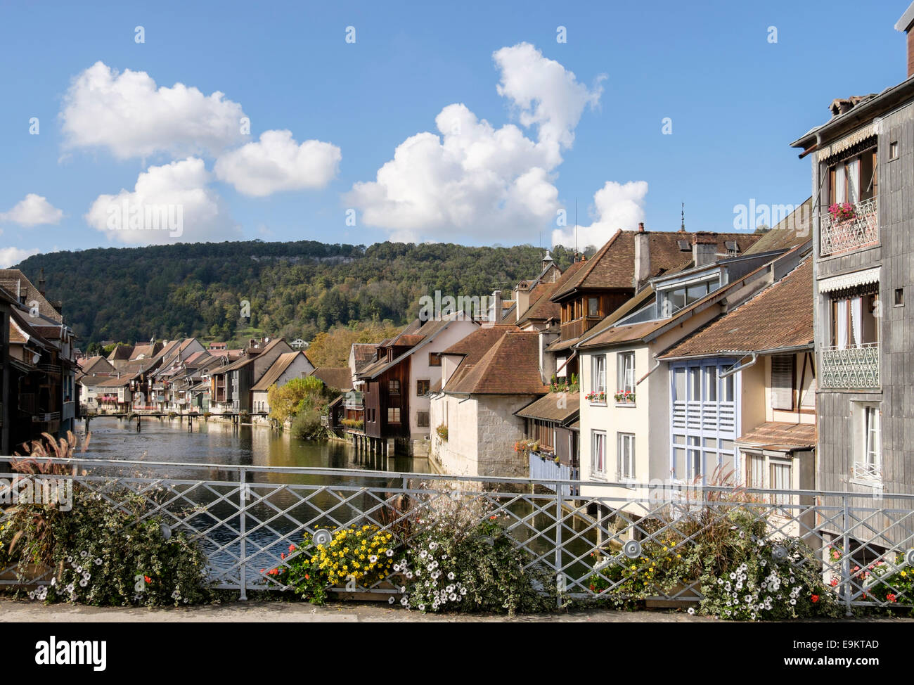 Malerische alte Häuser entlang dem Fluss Loue mit Blumen auf Brücke in Ornans, Doubs, Franche Comte, Frankreich Stockfoto