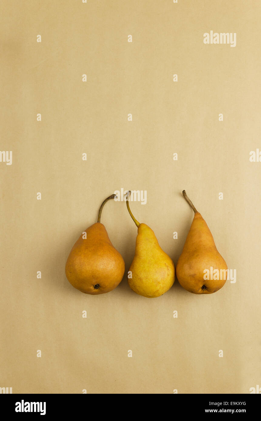Drei reife Birnen auf braunem Papierhintergrund mit textfreiraum (negativer Raum) Stockfoto