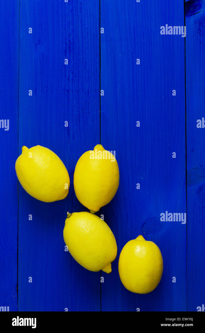 Mehrere Zitronen über blauen hölzernen Hintergrund mit textfreiraum (negativer Raum) Stockfoto