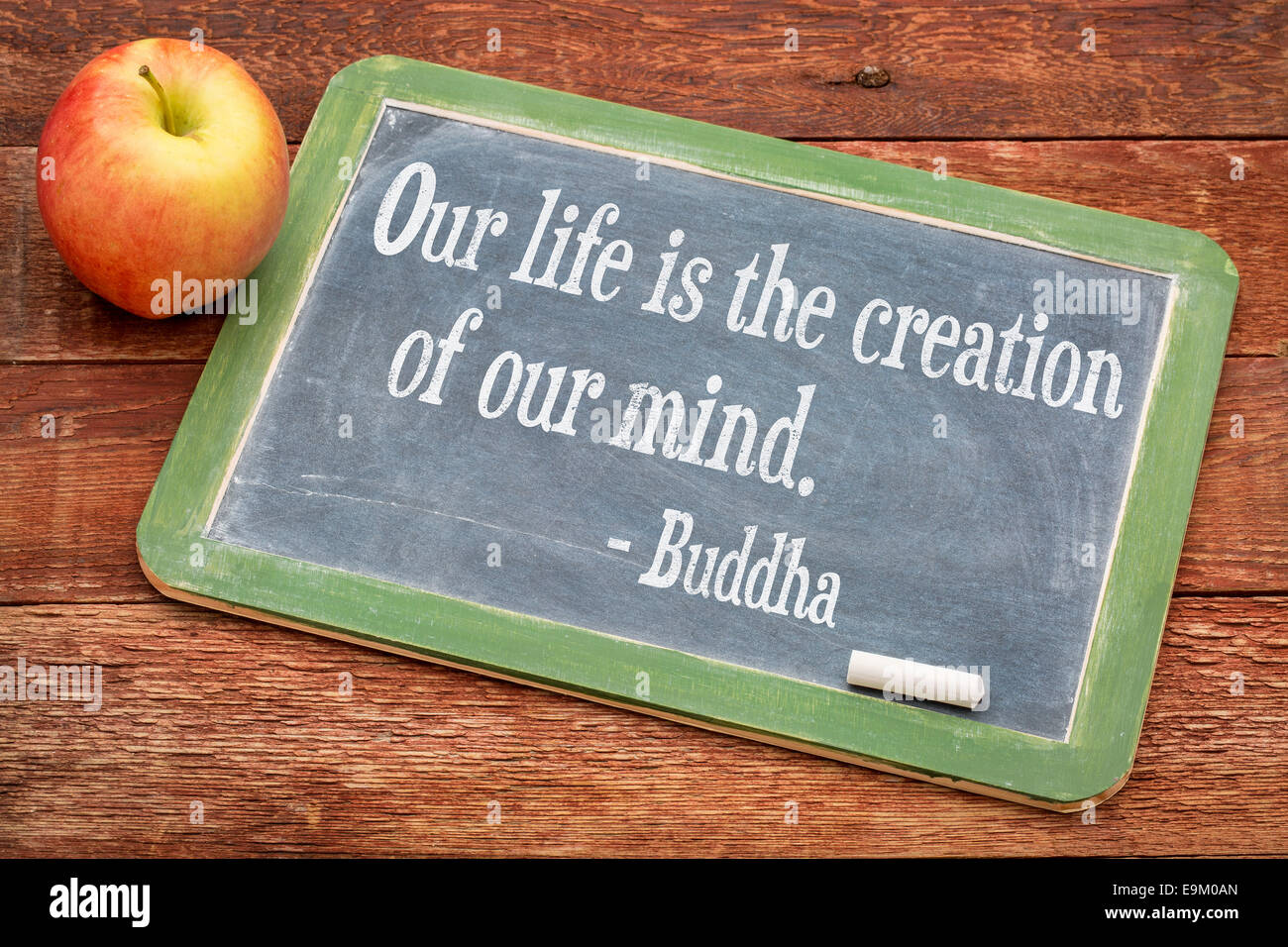 Unser Leben ist Schöpfung unseres Geistes - Buddha-Zitat auf einer Schiefertafel Tafel gegen rote Scheune Holz Stockfoto