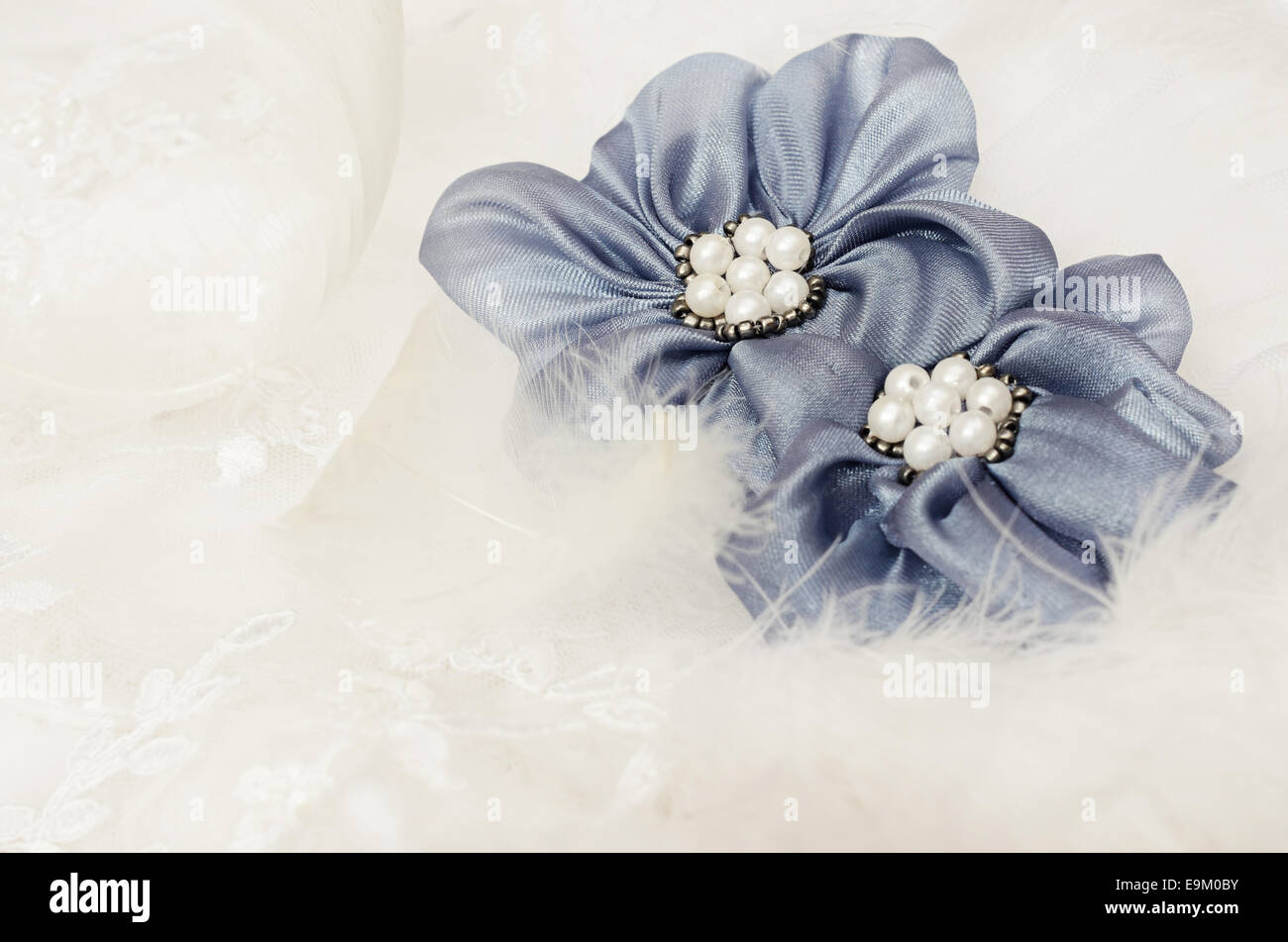 Blaue Textilblumen auf weißer Spitze Stockfoto