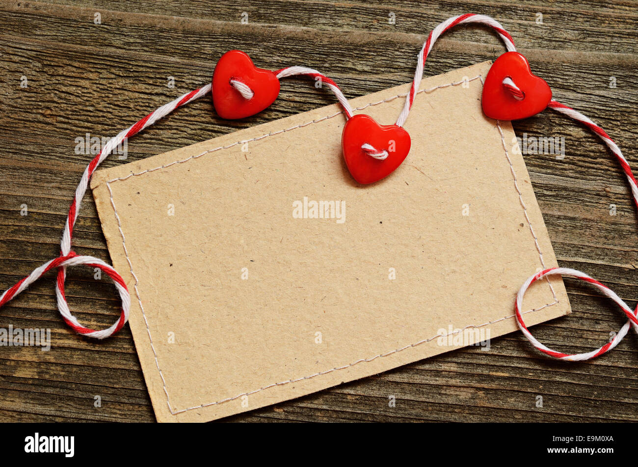 Drei Herzen und eine Karte auf hölzernen Hintergrund Stockfoto