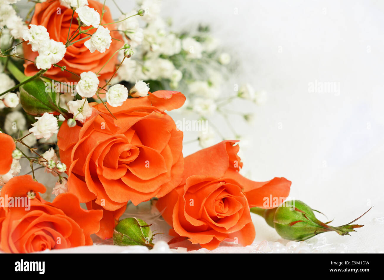 Orange Rosen auf weißes Hochzeitskleid Spitze Stockfoto