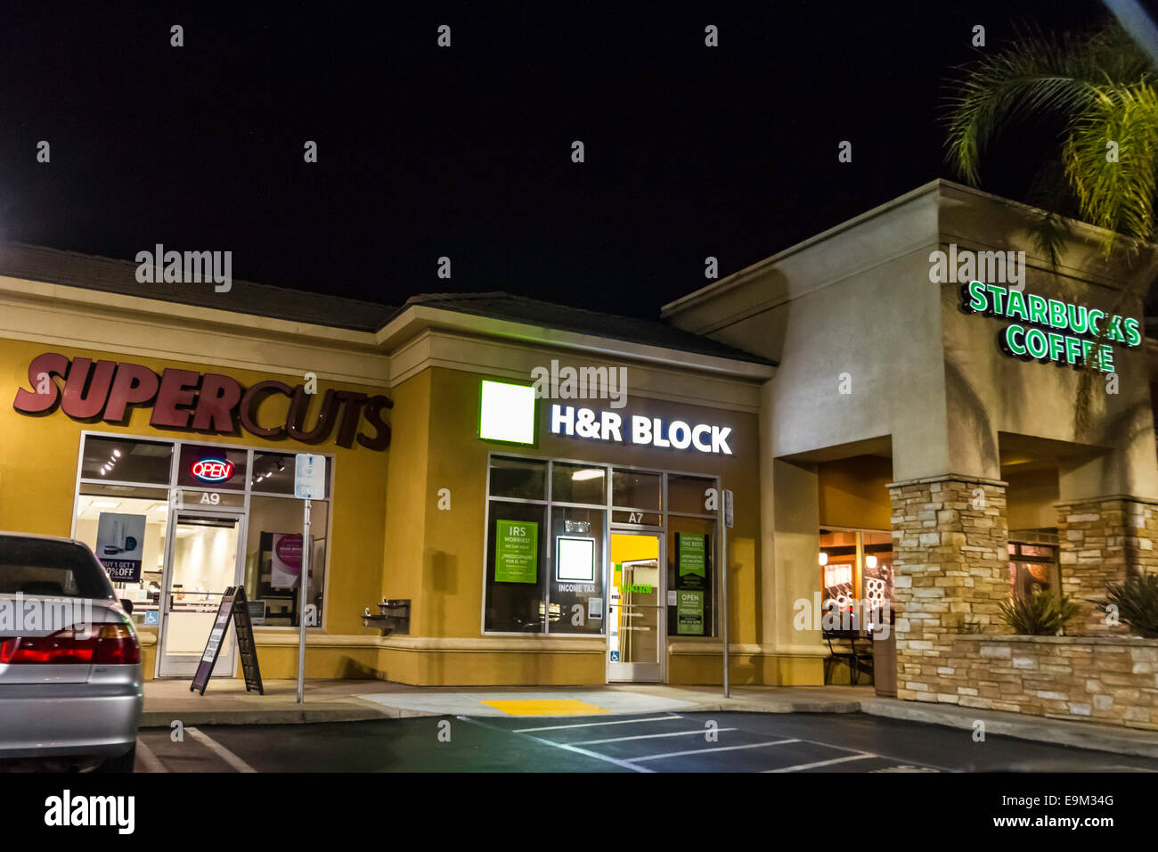 Ein Einkaufszentrum in Modesto, Kalifornien mit einem Supercuts, H & R Block Steuer-Aufsteller und ein Starbucks-Kaffee in der Nacht Stockfoto