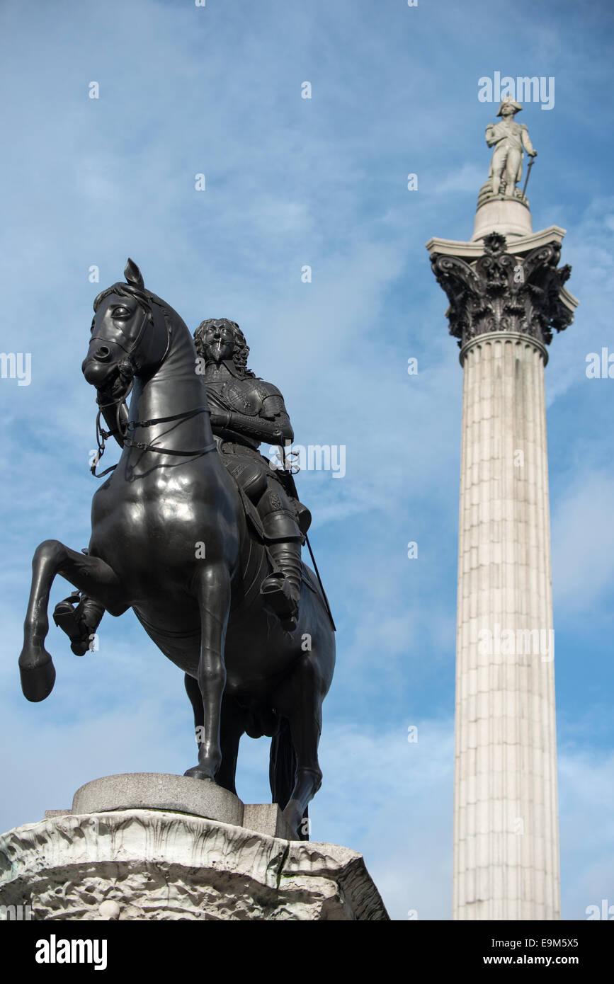 LONDON, Vereinigtes Königreich — die Reiterstatue von König Karl I. im Vordergrund, mit Nelsons Säule, die sich im Hintergrund am Trafalgar Square hervorhebt. Diese Szene zeigt zwei berühmte Denkmäler aus verschiedenen Epochen der britischen Geschichte in einem der berühmtesten öffentlichen Plätze Londons. Stockfoto