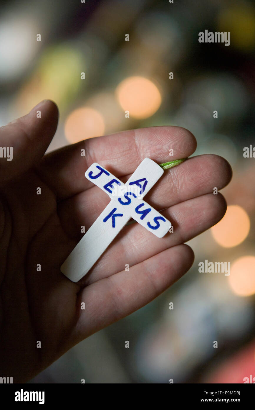 Person, die kleine Kreuz mit Text "Jesus Fragen" Stockfoto