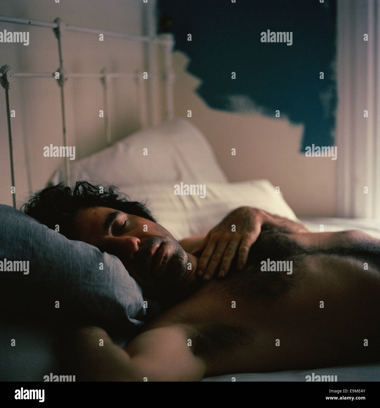 Ein Mann in einem Bett schlafen Stockfoto
