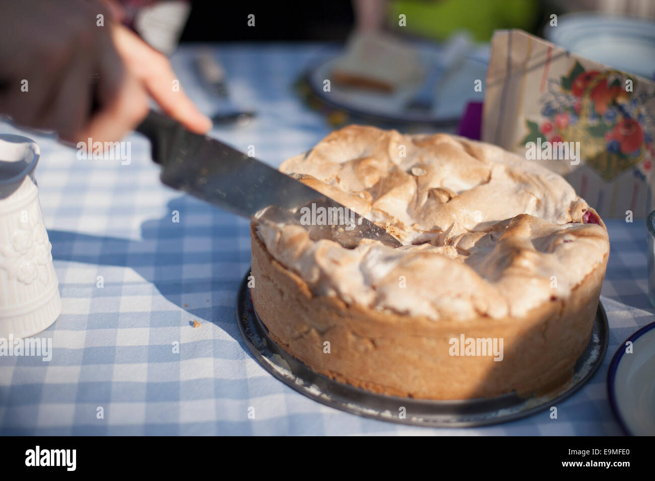 Bild von Hand schneiden Kuchen auf Tabelle abgeschnitten Stockfoto