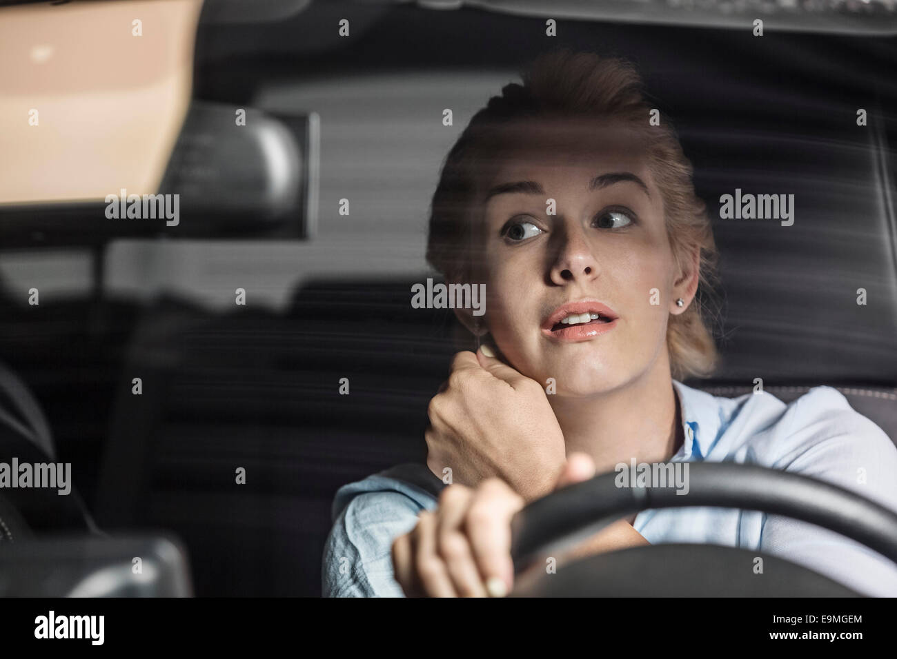 Mitte Erwachsene Frau im Rückspiegel während der Fahrt Auto suchen Stockfoto