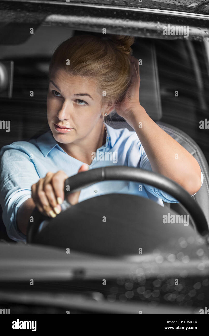 Mitte erwachsenen Frau betrachten sich im Rückspiegel beim Auto fahren Stockfoto