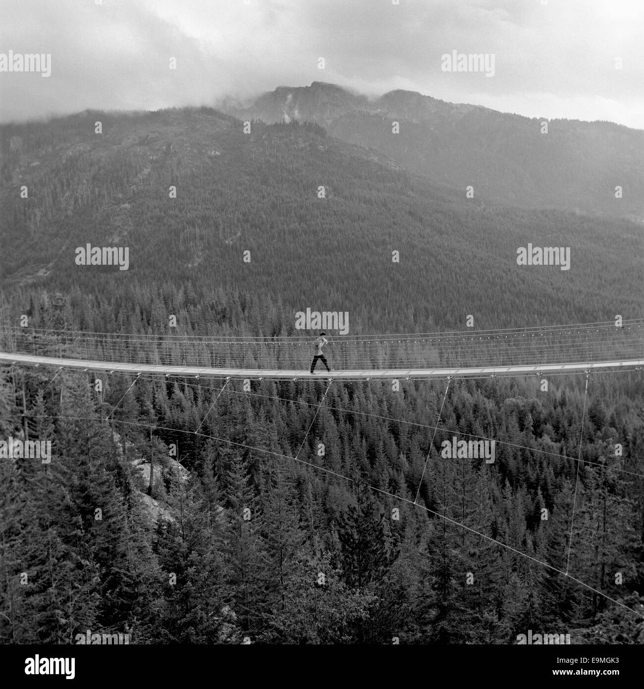 Mittleren Abstand von Mann Kreuzung Fußgängerbrücke über Wald Stockfoto