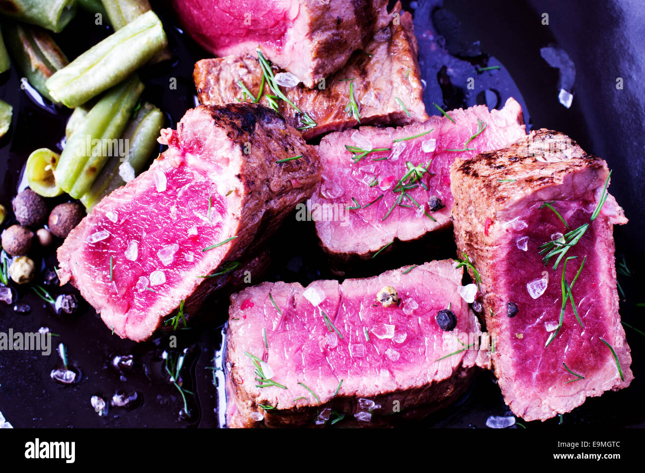 In Scheiben Rindfleischsteak auf einen Teller mit Bohnen Stockfoto