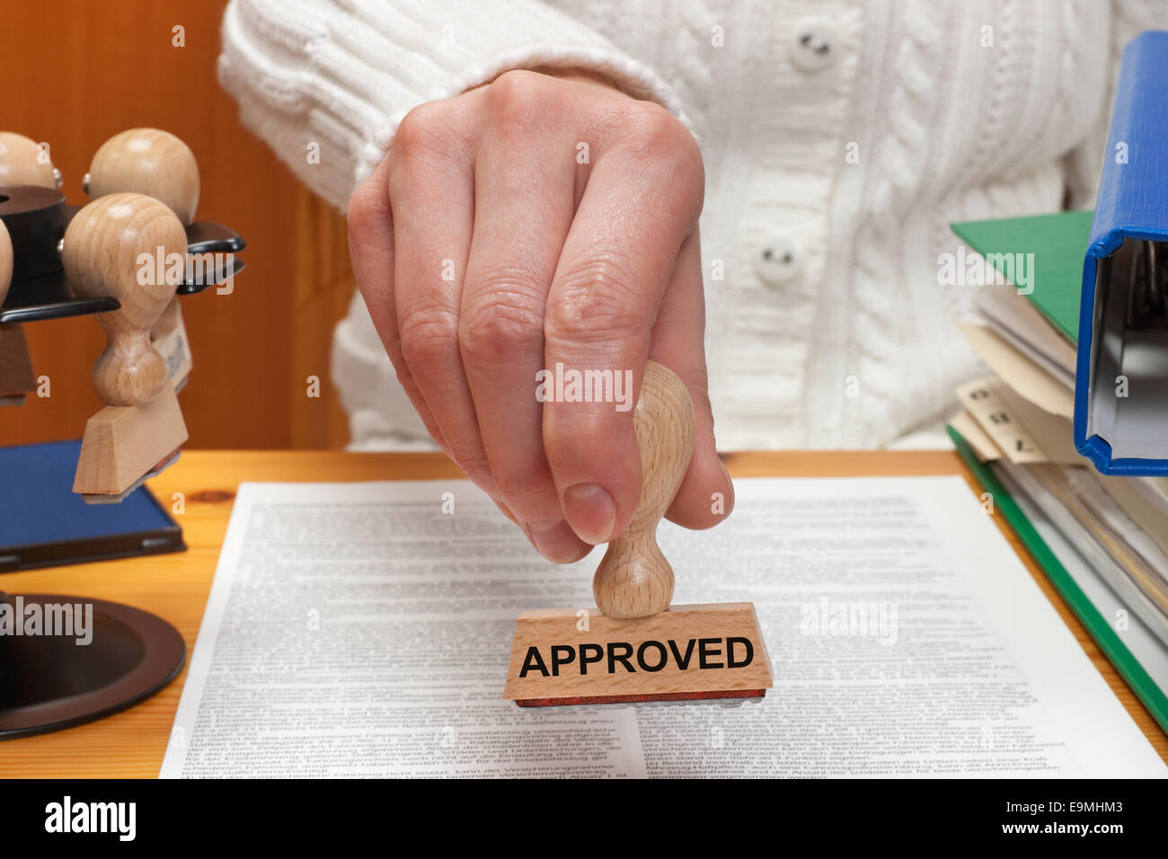 Ein Stempel mit der Aufschrift genehmigt wird in der Hand gehalten. Stockfoto