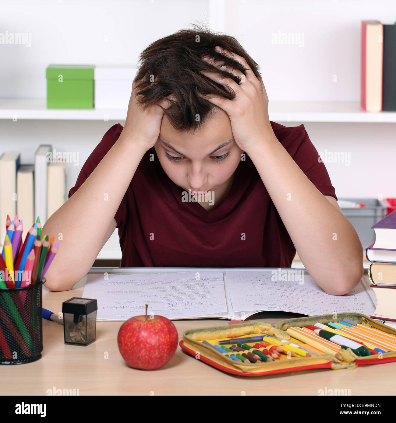 Junge Studentin hat Stress und ist verzweifelt in der Schule während der Hausaufgaben Stockfoto