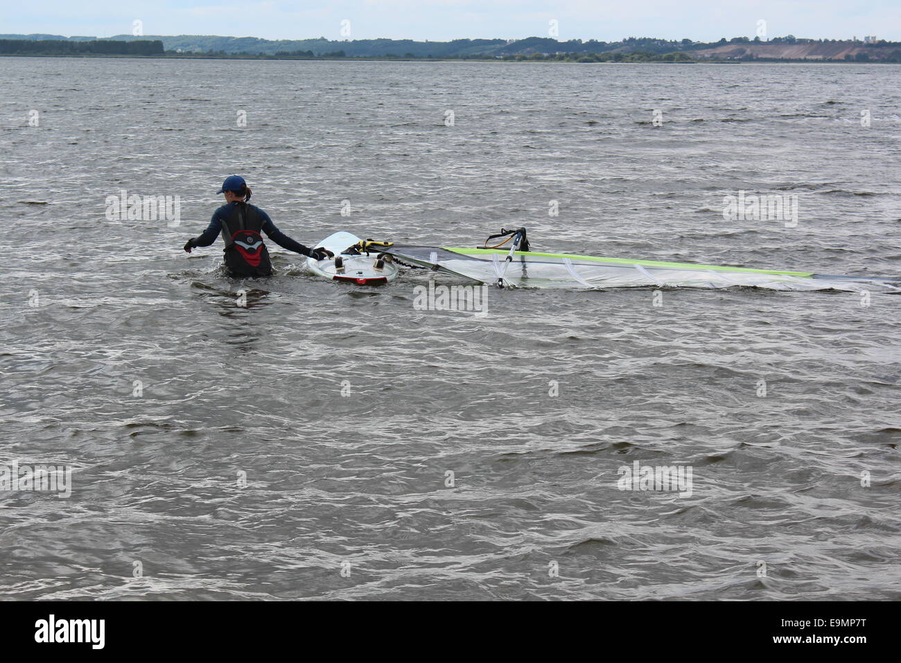 Polen, Rewa 17. August 2014: Anfänger weiblichen Windsurfer lernt Windsurfen. Sie steht im Wasser und zieht ihr Surfbrett. Stockfoto