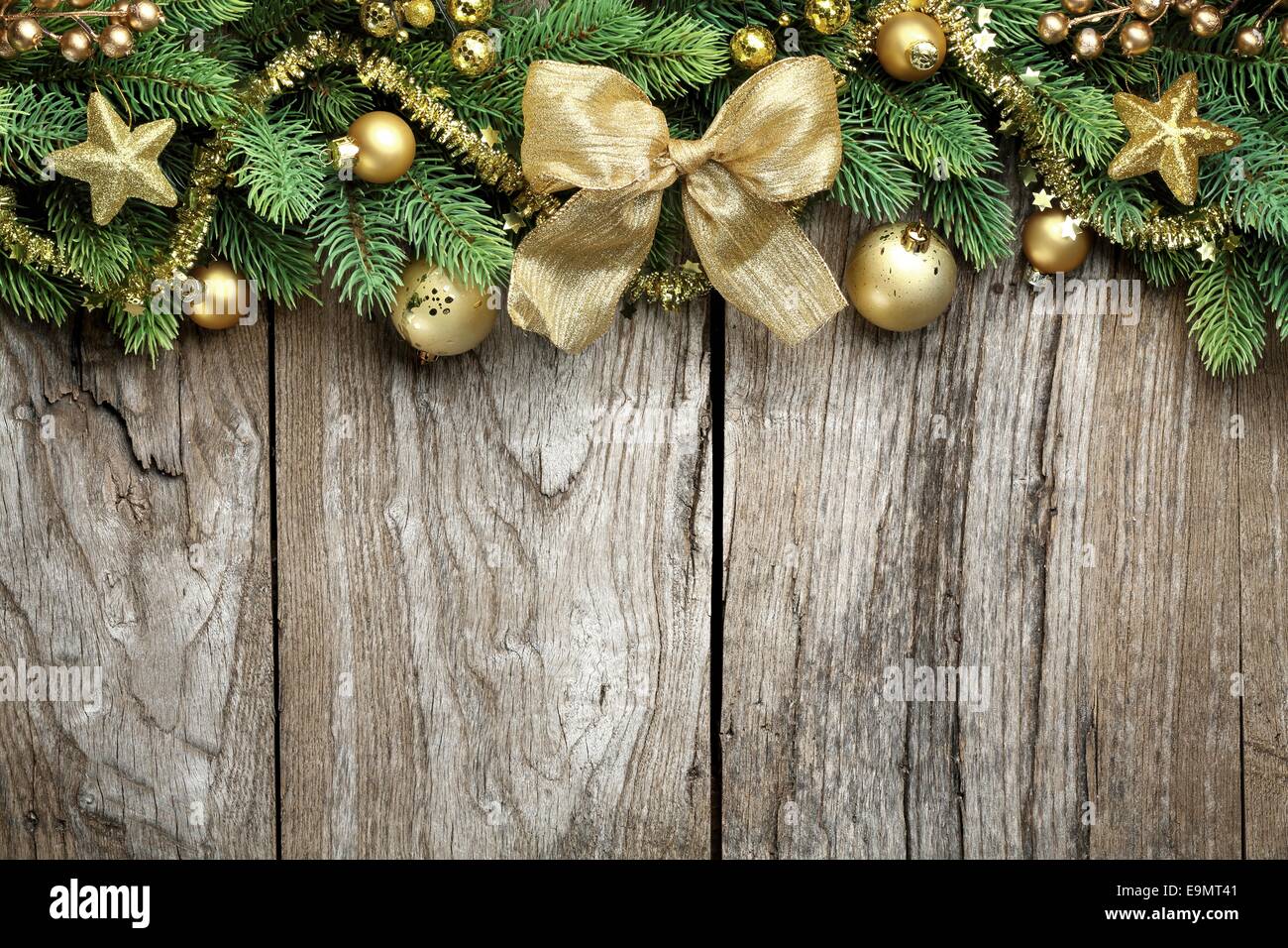 Tannenzweig und goldene Christbaumkugeln auf hölzernen Hintergrund Stockfoto