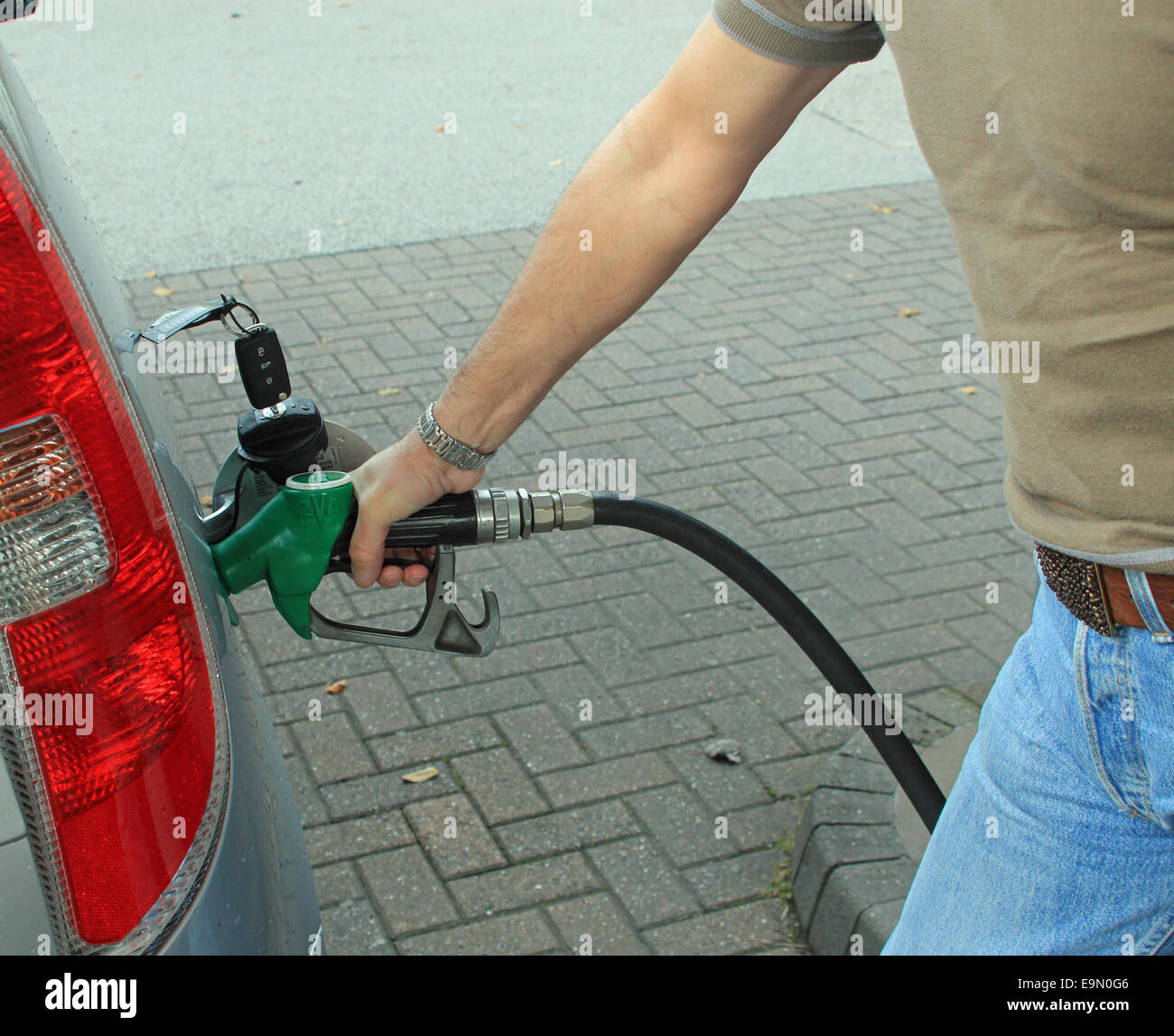 Close-up ein Fahrer sein Auto Tanken mit Benzin oder Diesel symbolisiert nicht elektrischen Autos, die Kosten für das Auto und Transport Stockfoto