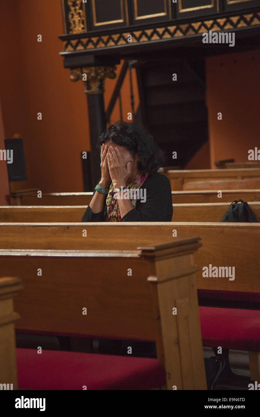 Frau tief im Gebet in einer katholischen Kirche.  Zielona Gora, Polen. Stockfoto
