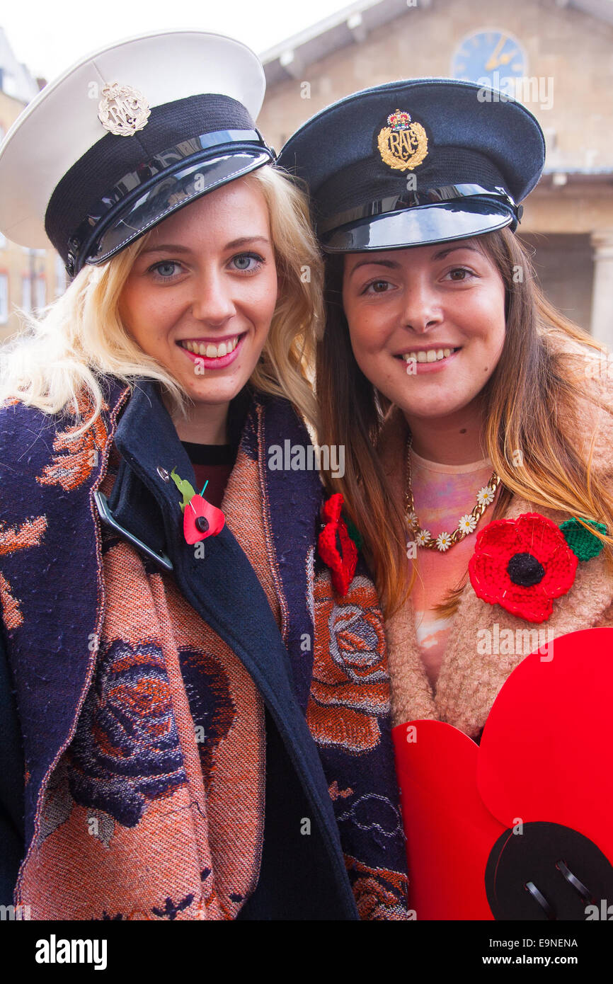 Covent Garden, London, UK. 30. Oktober 2014. Sie Royal British Legion Poppy Day in London Covent Garden, wo Bands, Chöre, Klassik und pop Musiker unterhalten Massen als Air Force Personal mit Spende Eimer Mohn verkauft, im Mittelpunkt, in der Hoffnung, von mehr als £ 1 Million zu erhöhen. Im Bild: Emma Nettleingham, links und Claire Harley von Billericay in Essex requirieren zwei Luftwaffe Offiziere Hüte. Bildnachweis: Paul Davey/Alamy Live-Nachrichten Stockfoto