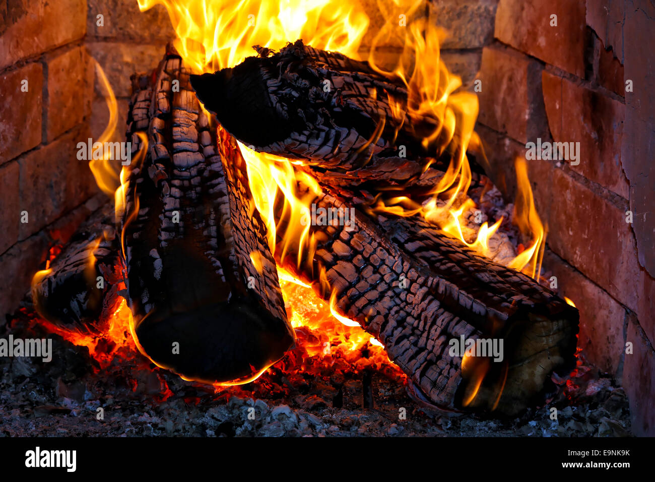 Heizen mit Feuerholz in einem Kamin Stockfoto