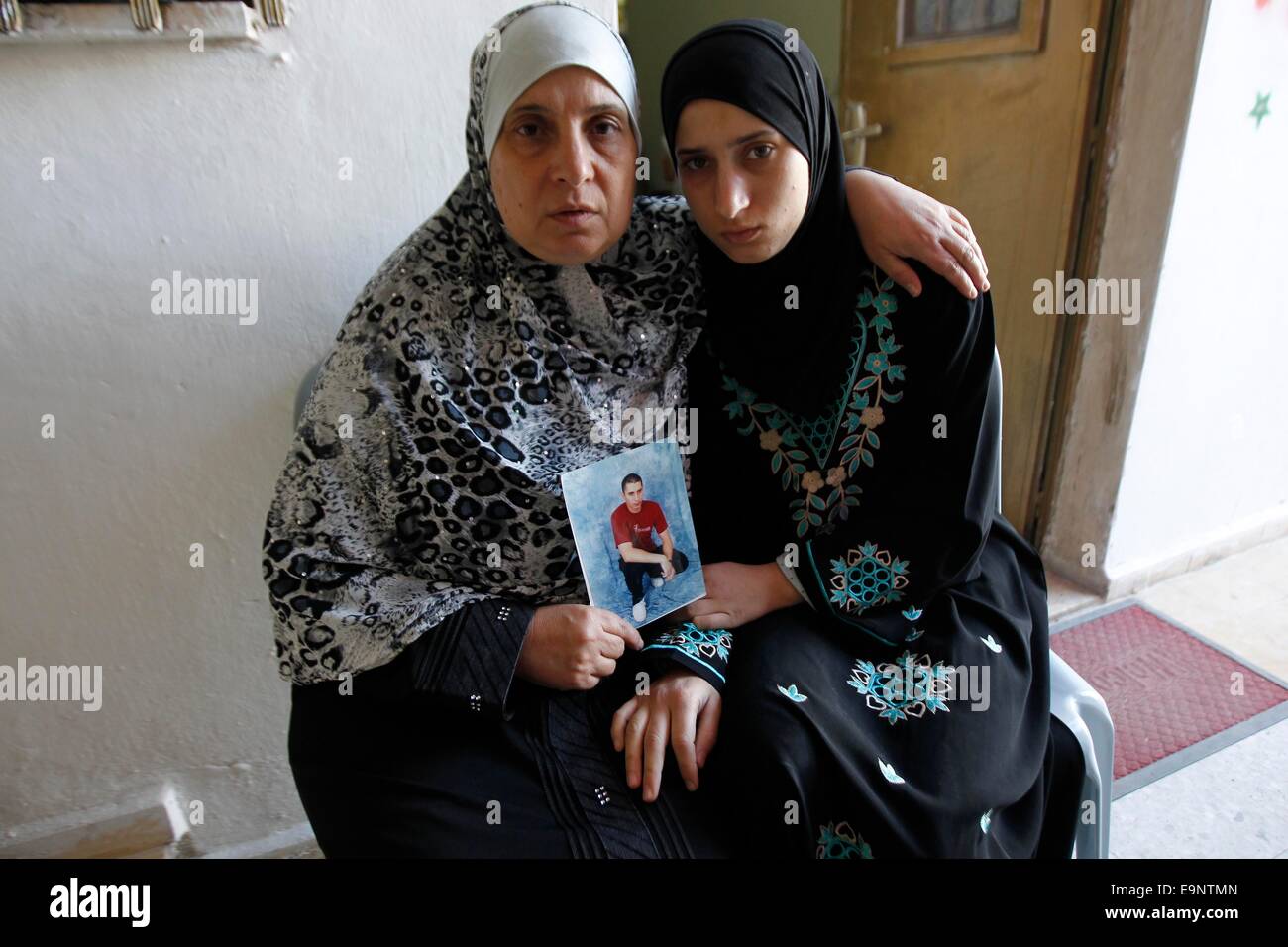 Jerusalem. 30. Oktober 2014. Die Mutter des palästinensischen Muatnaz Hijazi (L) hält sein Bild zu Hause im Stadtteil Abu Tor, Ost-Jerusalem, am 30. Oktober 2014. Der prominente rechtsextremen jüdische Aktivist Yehuda Glick wurde kritisch späten Mittwochabend nach einem politischen Ereignis eintreten für jüdische Präsenz in Jerusalemer Tempelberg, eine ständige Quelle von Streit zwischen Arabern und Juden erschossen. Bildnachweis: Xinhua/Alamy Live-Nachrichten Stockfoto