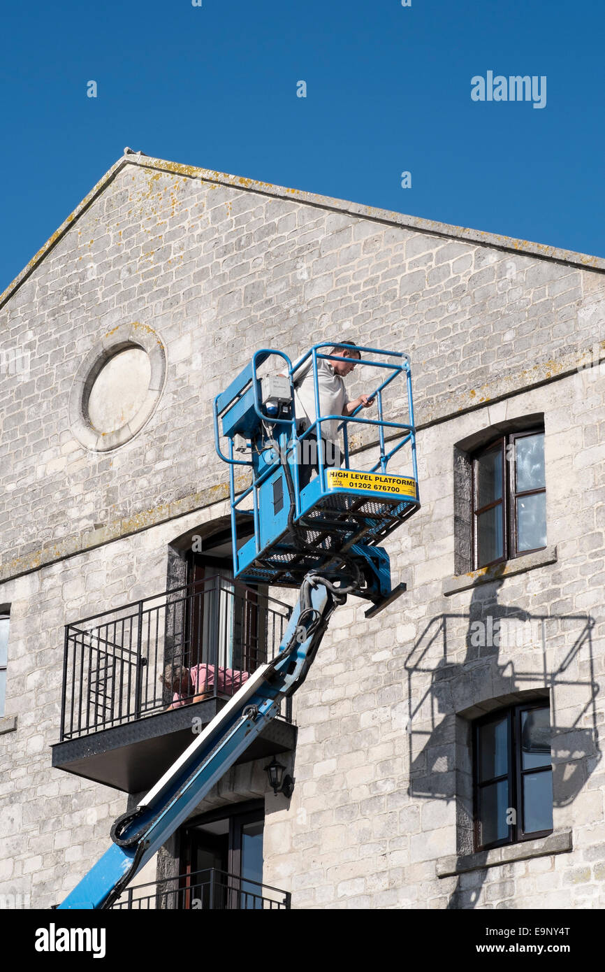 Mann arbeitet in hydraulischer Hubarbeitsbühne Lift Maschine Stockfoto