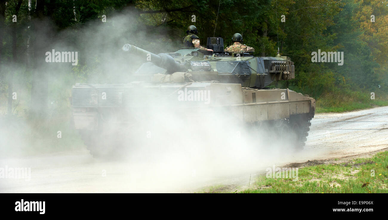 Leopard 2-Panzer fahren in staubiger Umgebung mit Turm nach hinten gedreht Stockfoto