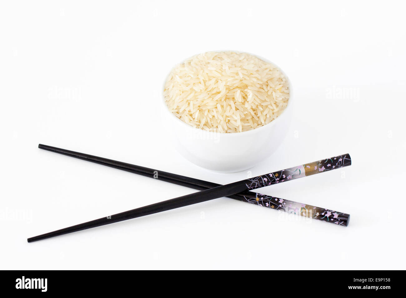 Schüssel Reis mit Stäbchen auf weißem Hintergrund Stockfoto