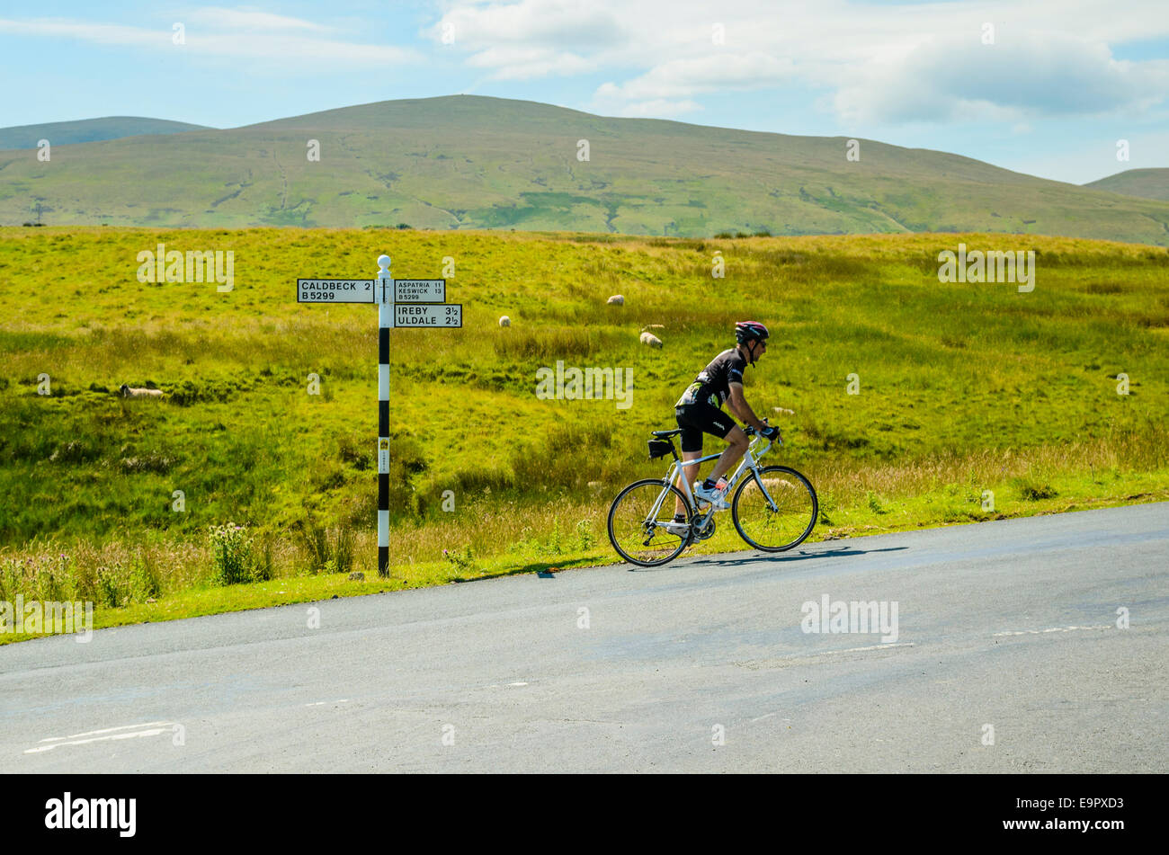 Radfahrer und Straße unterzeichnen in den Fjälls des englischen Lake District Stockfoto