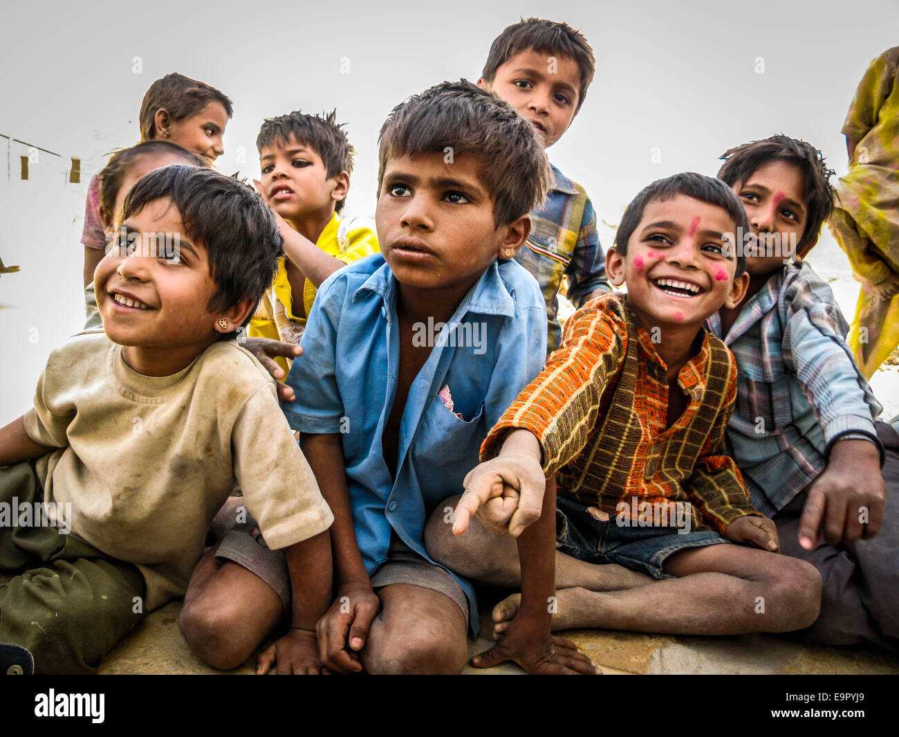 Glückliche indische Kinder draußen sitzen und lachen über Wüste Dorf in Jaisalmer, Rajasthan, Indien. Stockfoto