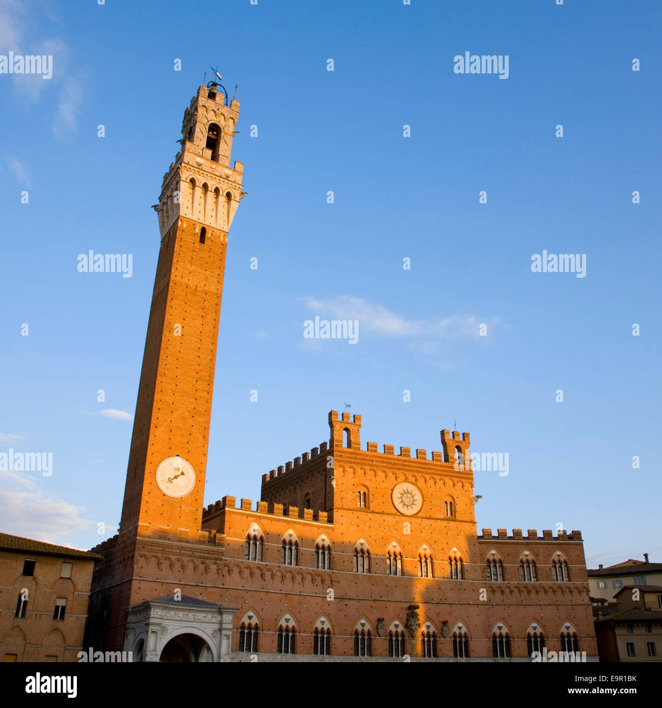 Siena, Toskana, Italien. Der Palazzo Pubblico (Palazzo Comunale) und Torre del Mangia beleuchtet von der untergehenden Sonne, Piazza del Campo. Stockfoto