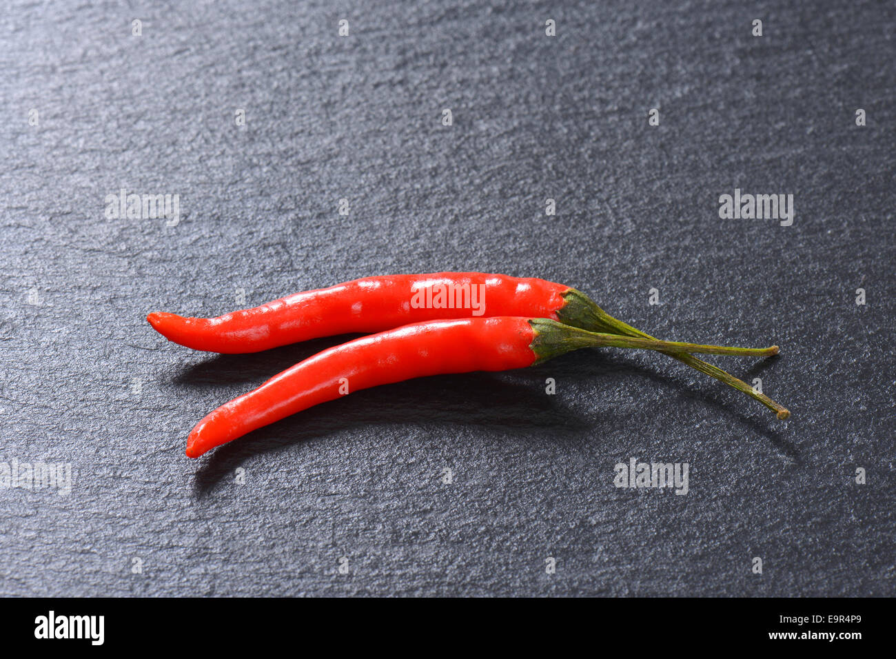 Rote Chilischoten auf Schiefer Stockfoto