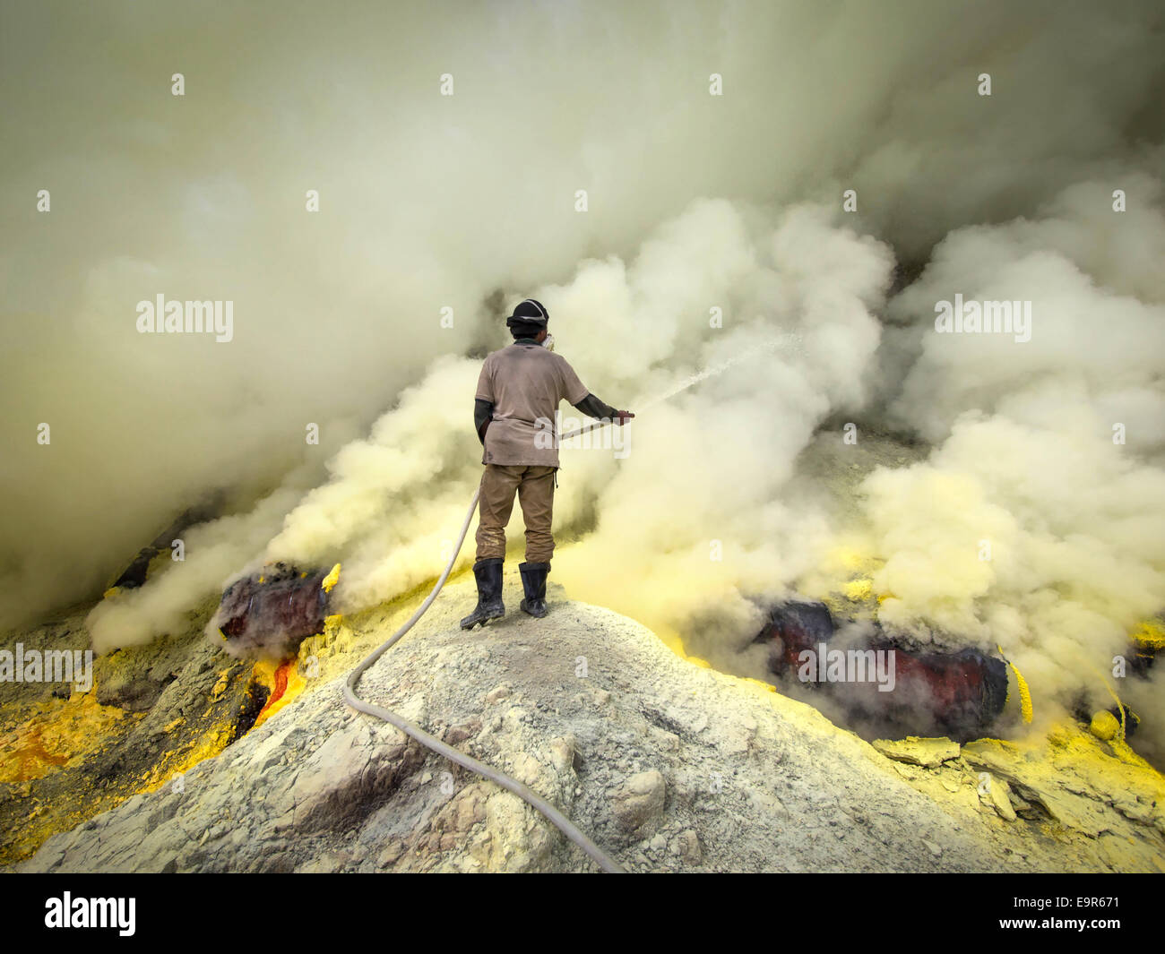 Schwefel-Miner "cooling off" Rohre für den Schwefel Bergbau im Inneren des Kraters der Kawah Ijen Vulkan, Ost-Java, Indonesien. Stockfoto