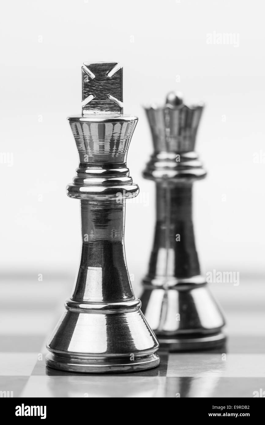 Robuste Messing König und die Königin Figuren auf einem Schachbrett. Flachen DOF zur Betonung des mächtigen Königs verwendet. Stockfoto