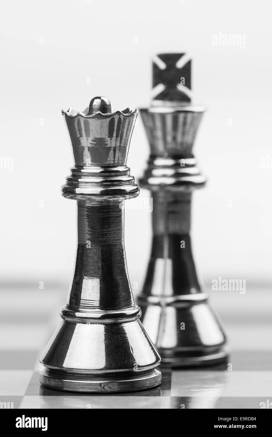 Robuste Messing Queen und King Figuren auf einem Schachbrett. Flachen DOF zur Betonung der mächtige Königin verwendet. Stockfoto
