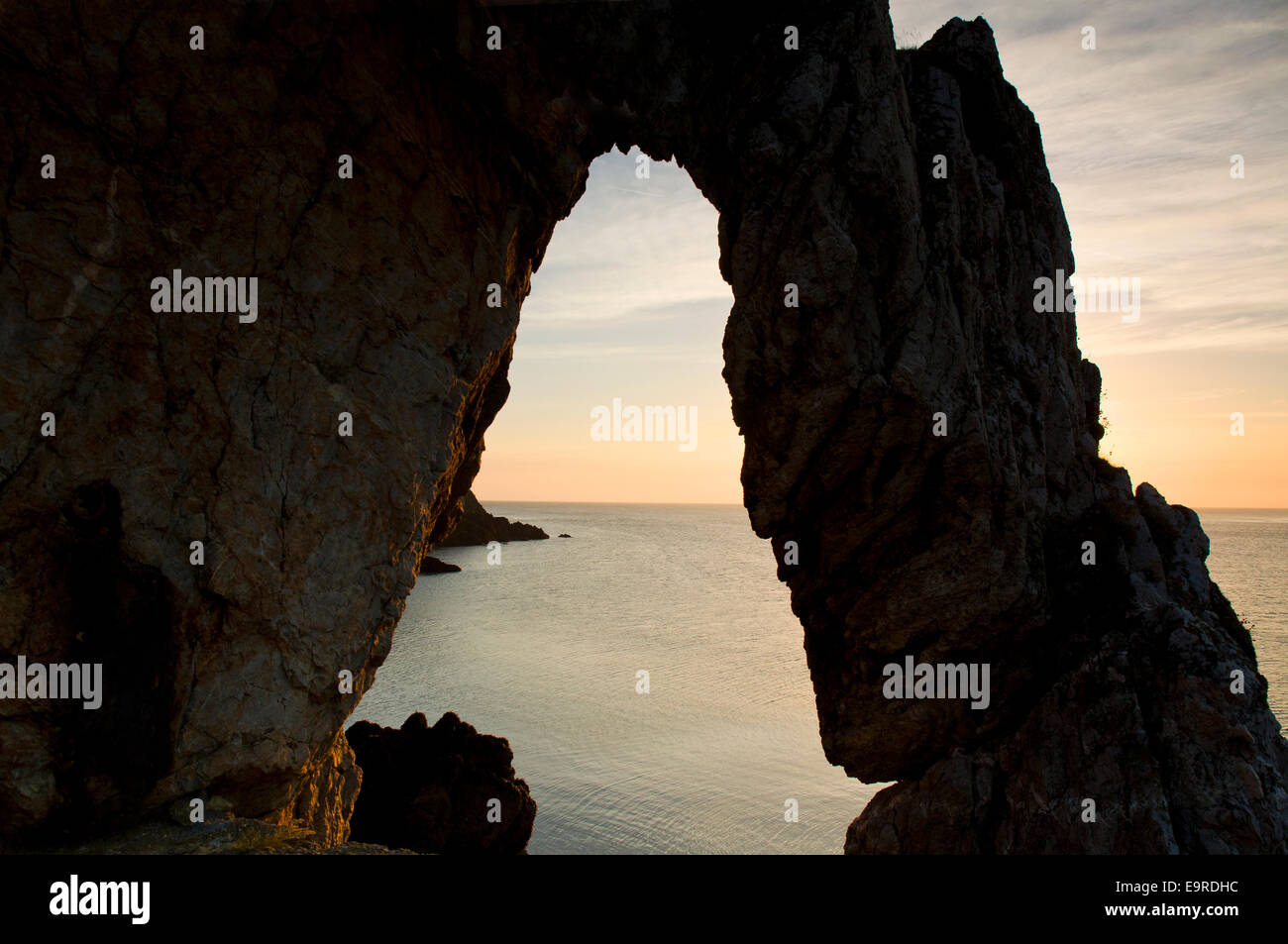 Natürlichen Felsbogen mit Blick aufs Meer um Sonnenaufgang in Porth Wen Bucht an der Nordküste auf Isle of Anglesey, North Wales U Stockfoto