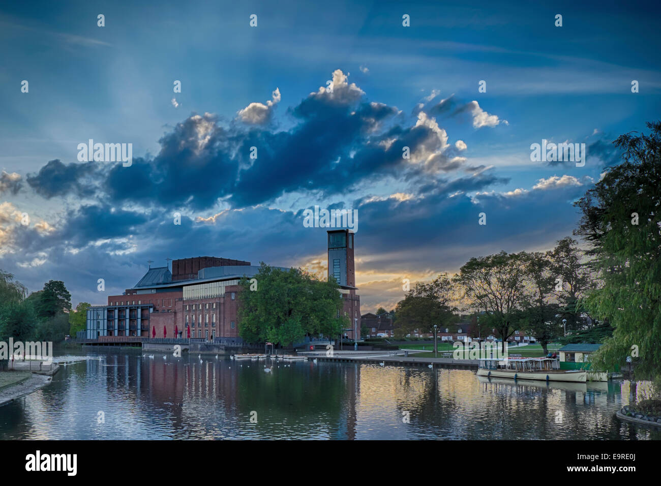 Der Royal Shakespeare Company Swan Theatre in Stratford-upon-Avon bei Sonnenuntergang aus über den Fluss mit Strahlen des Sonnenlichts Stockfoto