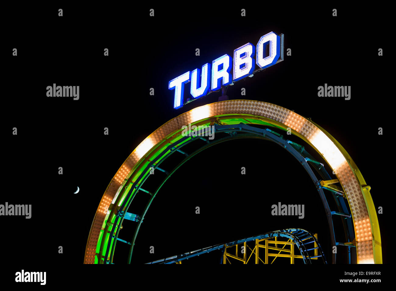 Beleuchtete "Turbo" Zeichen auf einer Schleife von einer Achterbahn in der Nacht Stockfoto
