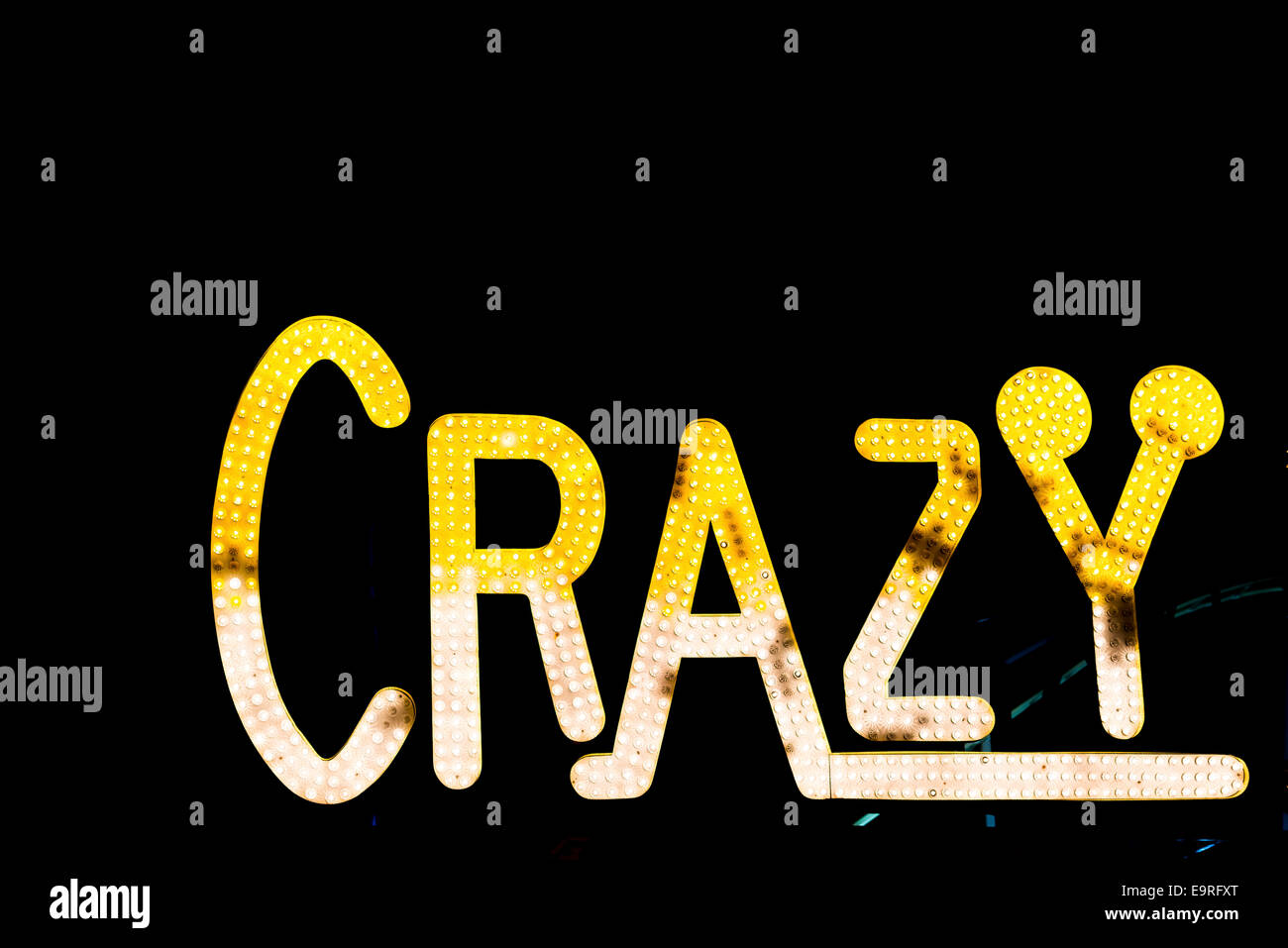 "Crazy" beleuchtet Zeichen nachts, mit gelben und weißen Glühbirnen Stockfoto
