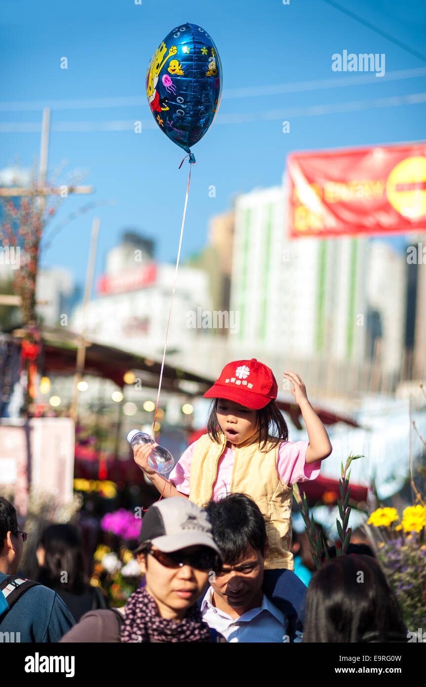 Junges Mädchen hält einen Ballon auf dem jährlichen Neujahr Blumenmarkt im Victoria Park, Hong Kong Stockfoto