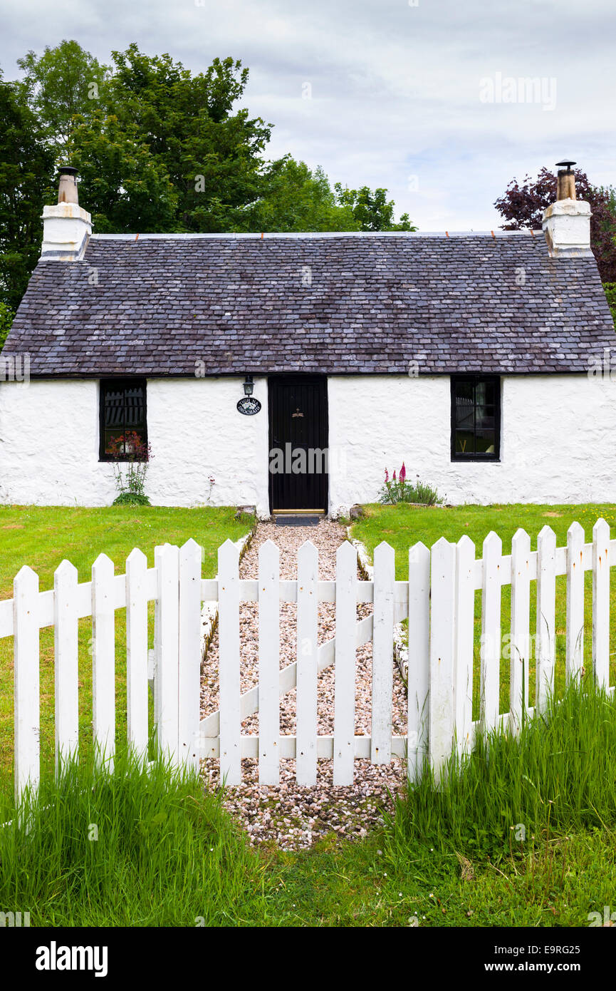 Malerische traditionelle Highland Stein Bungalow Ferienhaus mit weißen Paling Zaun am Port Appin, Argyllshire in den Highlands Scotla Stockfoto