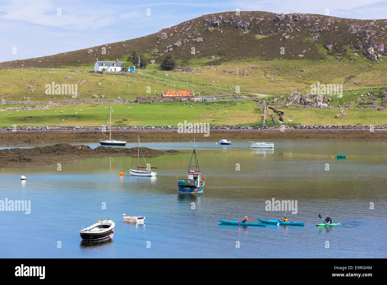 Familienausflug, Vater und Kinder im alten Hafen von Dornie Kajaks paddeln in der Nähe von den Summer Isles, auf der Westküste von Schottland Stockfoto