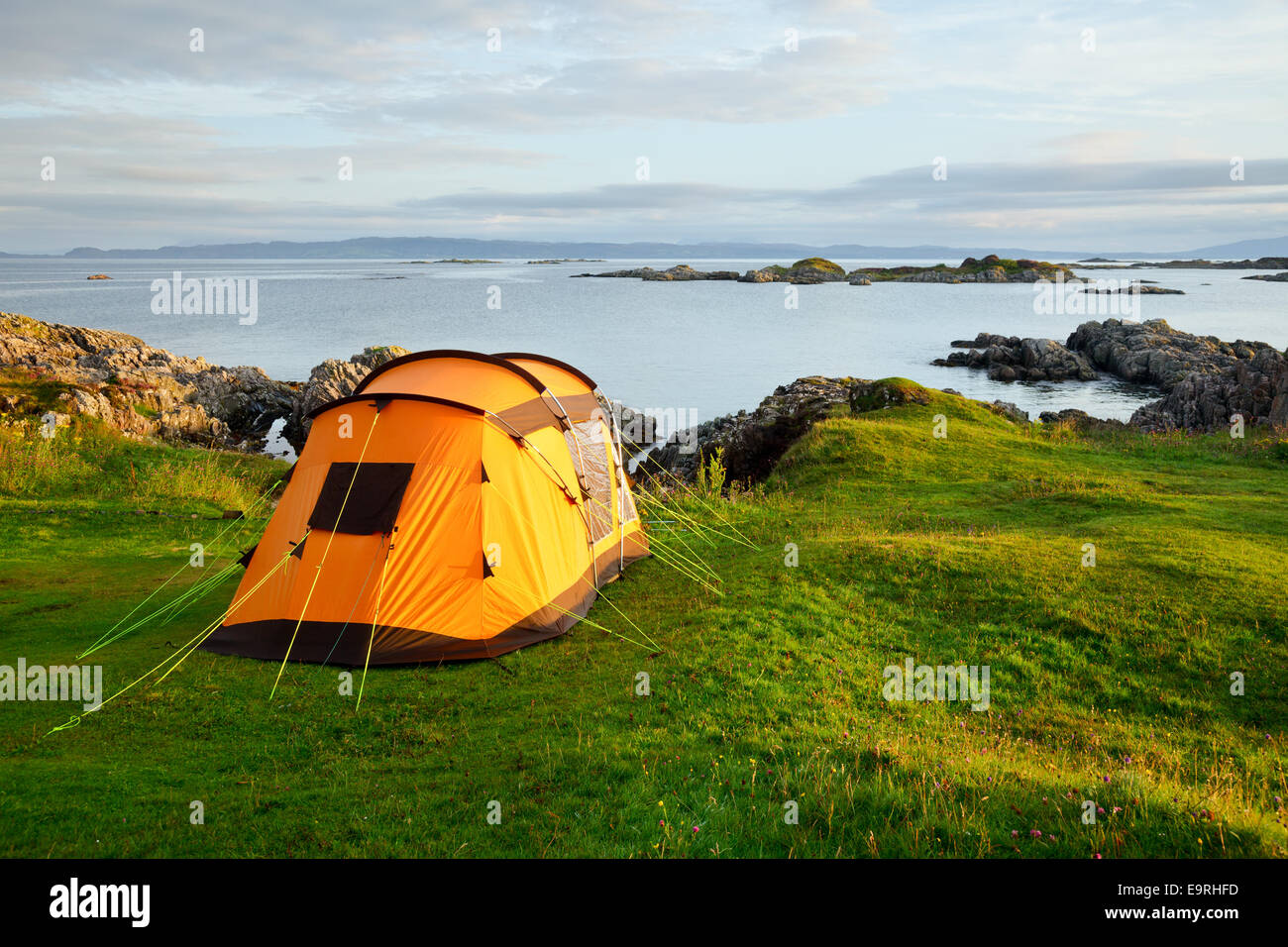 Orange camping Zelt an einem Ufer in ein Licht des Morgens Stockfoto