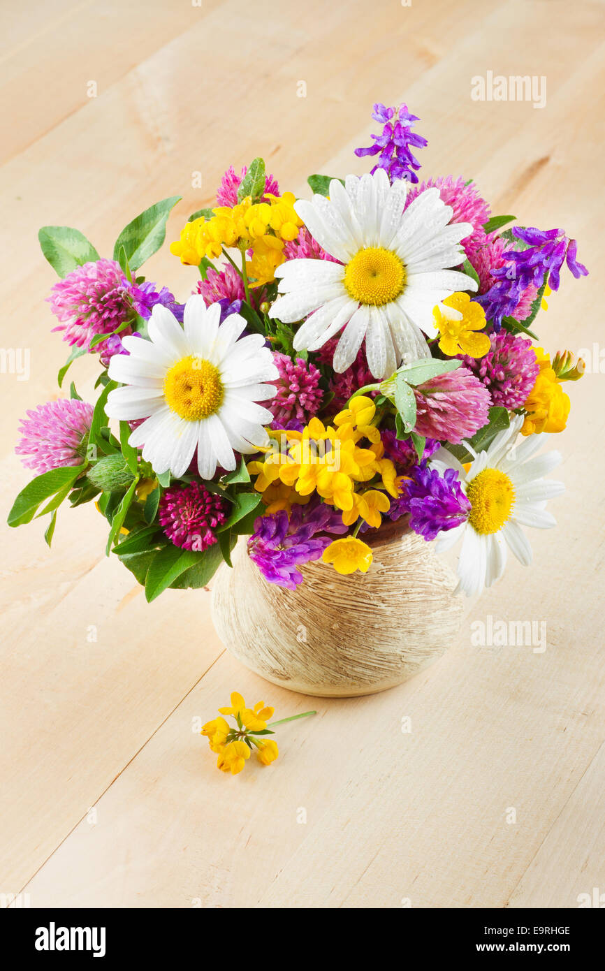 Vase mit Bouquet von heilende Kräuter und Blumen auf Holztisch Stockfoto