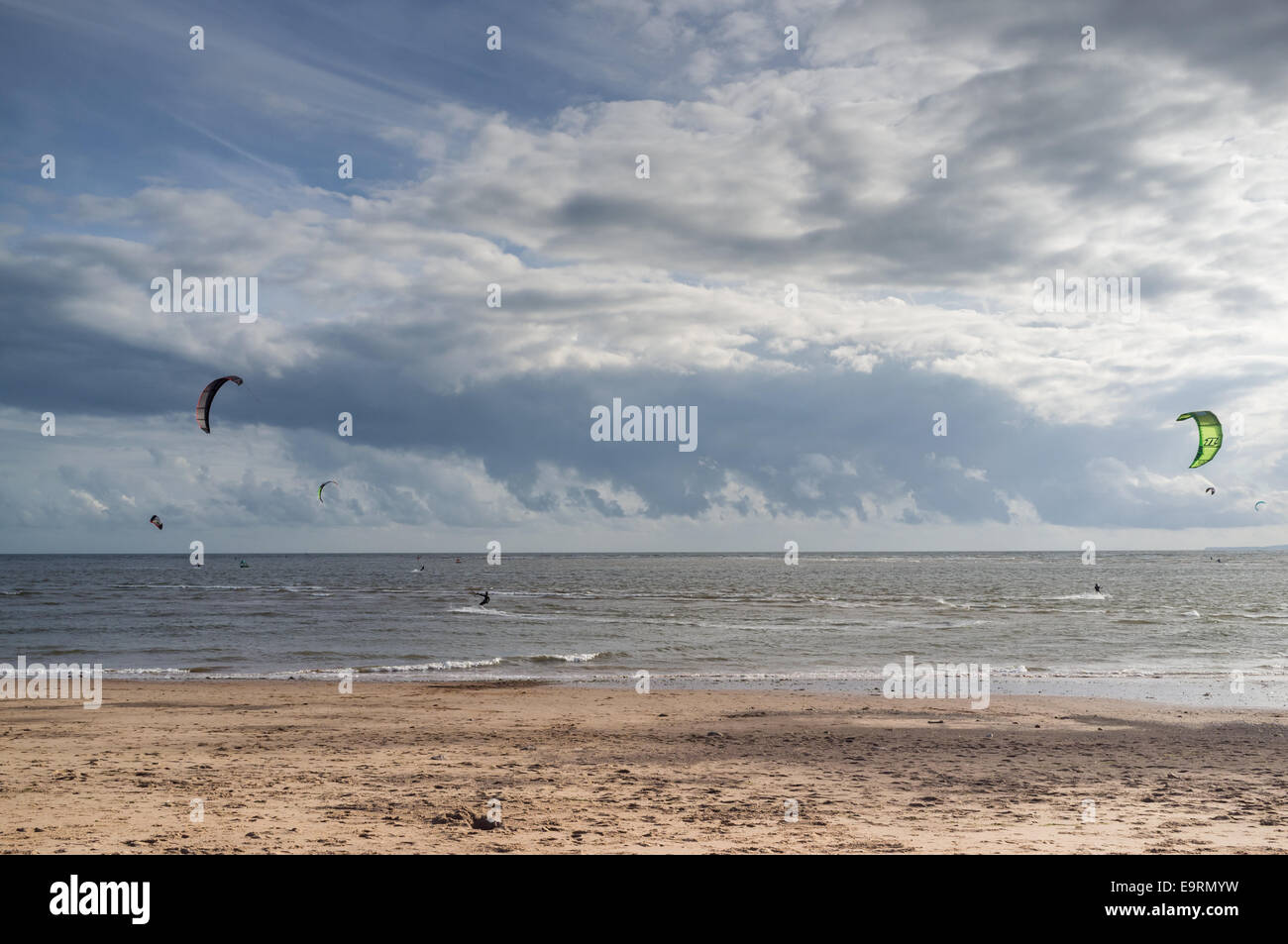 Kite-Surfer an einem windigen Tag in Exmouth in Devon, England. Gute Bedingungen zum Kitesurfen gegen einen dramatischen Himmel und Horizont. Stockfoto