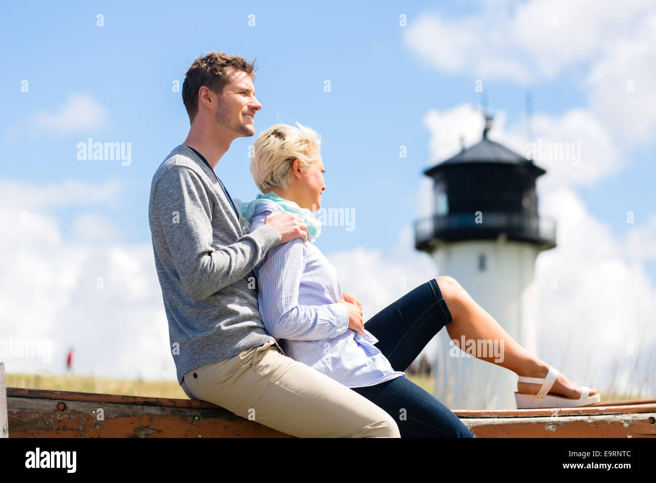 Paar beim Romantikurlaub im deutschen Nordsee Strand Düne vor Leuchtturm Stockfoto